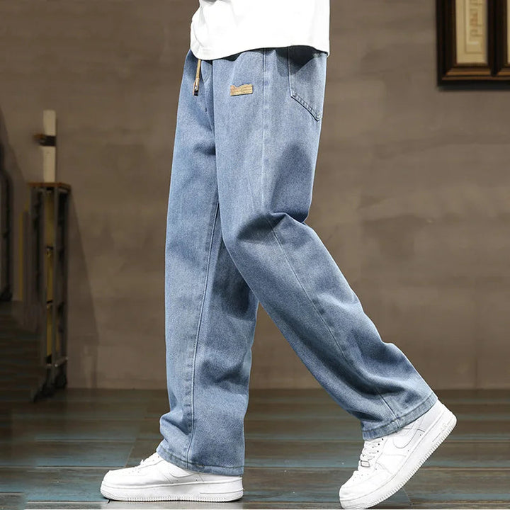 Streetwear men's denim joggers, relaxed fit, wide leg, and drawstring waist for casual comfort.