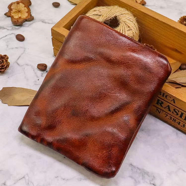 Detailed shot of the secure snap closure on a men's distressed leather bifold wallet.