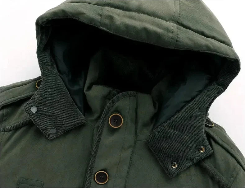 Man wearing a rugged men's winter jacket, hiking in a snowy highland landscape.