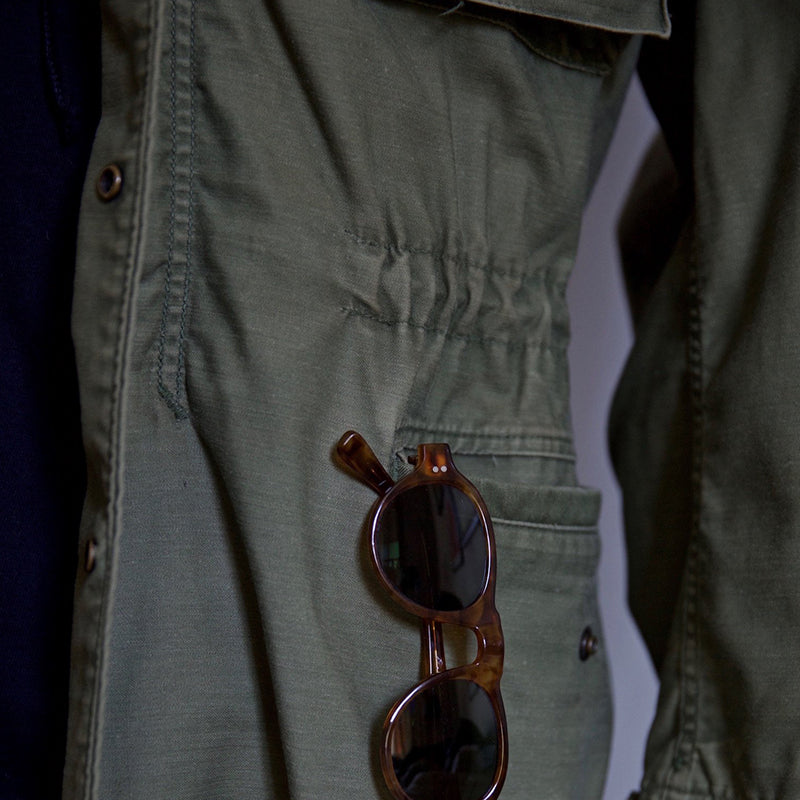 Versatile men's green hooded field jacket for outdoor adventures. Rugged utility style with storm protection.
