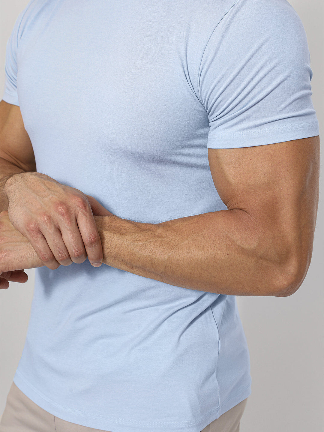 Active man stretching in a Men's Sevilla Performance Tee. Versatile athletic shirt.