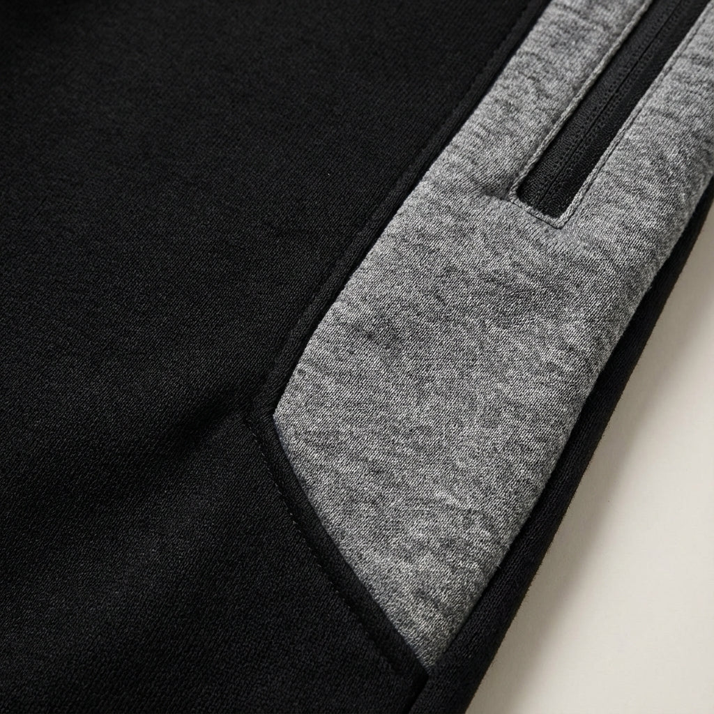 Close-up of men's athletic jogger pants showing zipper detail on leg and slim silhouette