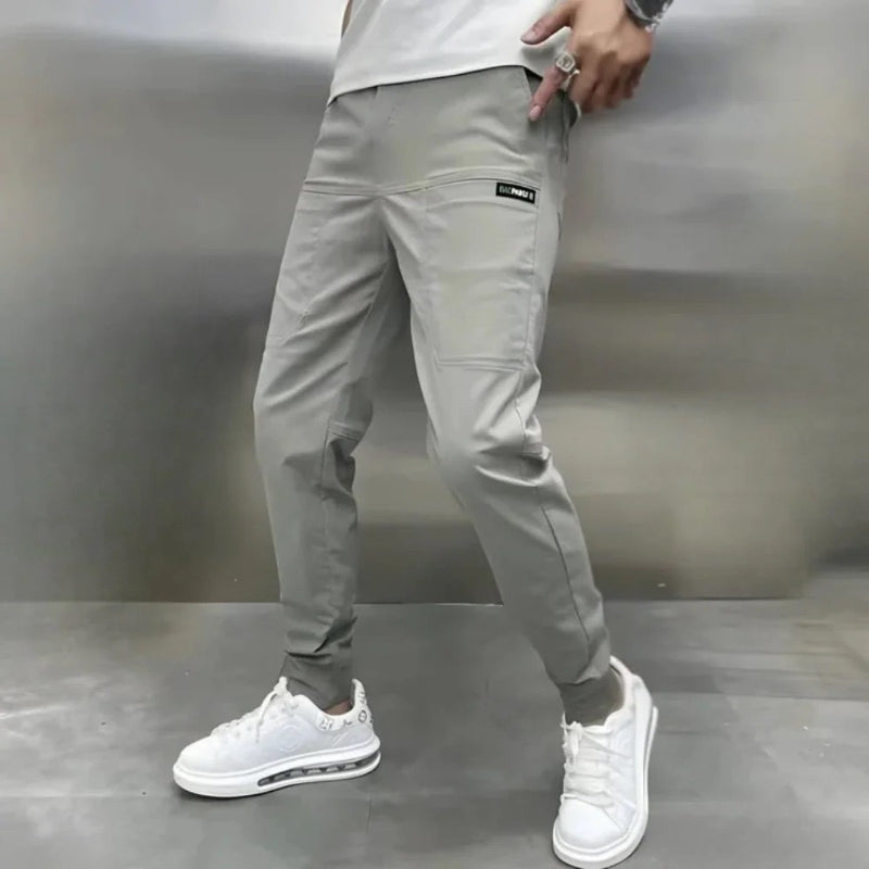 Stylish men's slim fit cargo pants in a dark shade, showcasing modern fashion and a sharp silhouette.