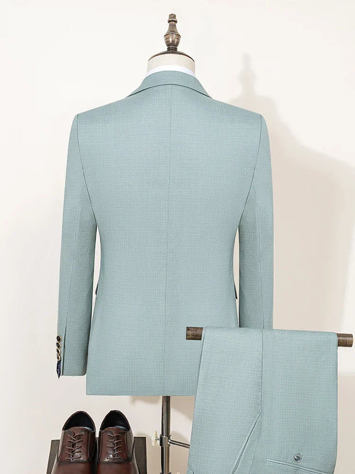 Tailored men's slim fit green three-piece suit with vest, perfect for summer weddings.