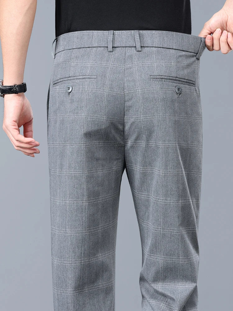 Man modeling slim fit plaid dress pants, showcasing a modern men's fashion outfit.