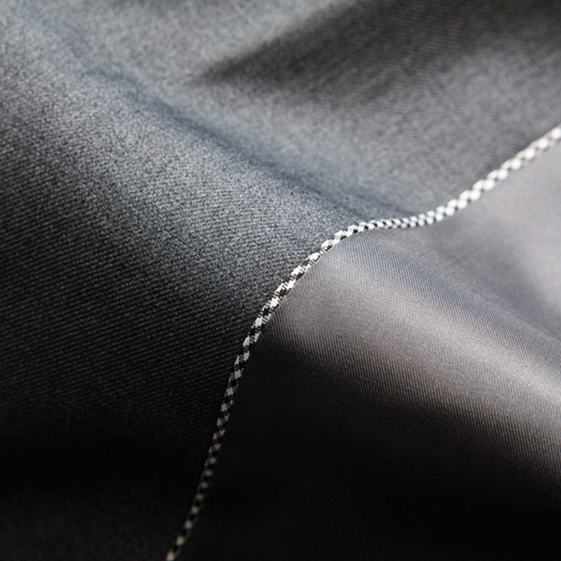 Close-up of men's tailored slim fit three-piece suit, showing jacket lapel, waistcoat buttons & fabric.