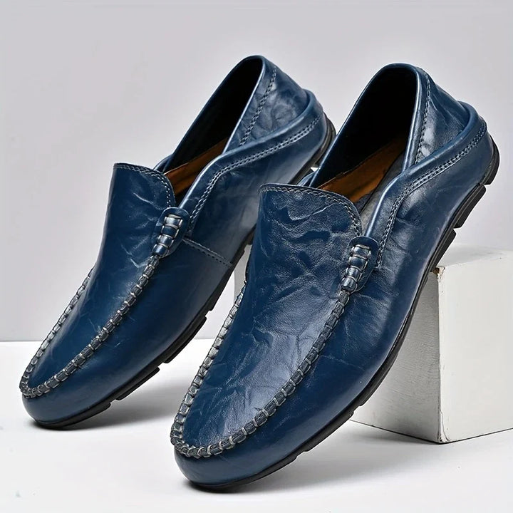 Navy blue men's slip-on loafers. Comfortable, classic style for formal, casual, or work footwear.