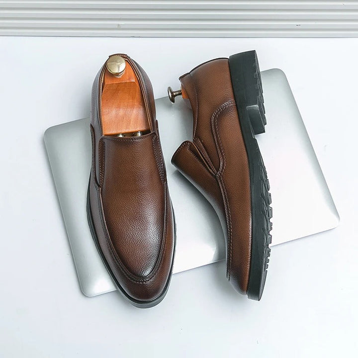 Brown men's slip-on loafers with a polished finish, offering casual comfort & dress style.