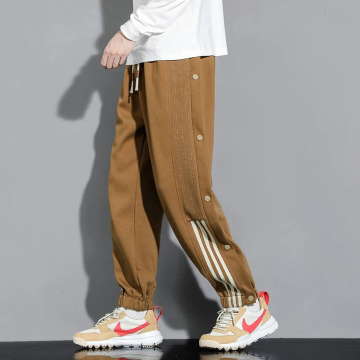 Versatile men's snap-track joggers in grey, perfect for streetwear, athletic activities, or comfortable loungewear.