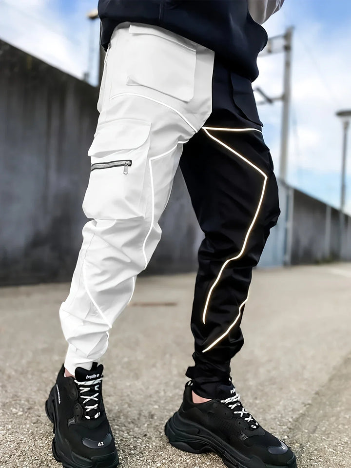 Man modeling men's Stealth reflective cargo jogger pants, showcasing urban street style.