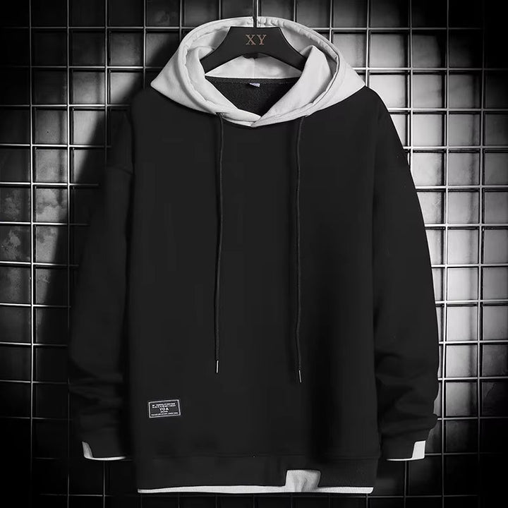 Casual men's dual-tone pullover hoodie. Offers everyday comfort and a stylish layered hem, great for modern streetwear.