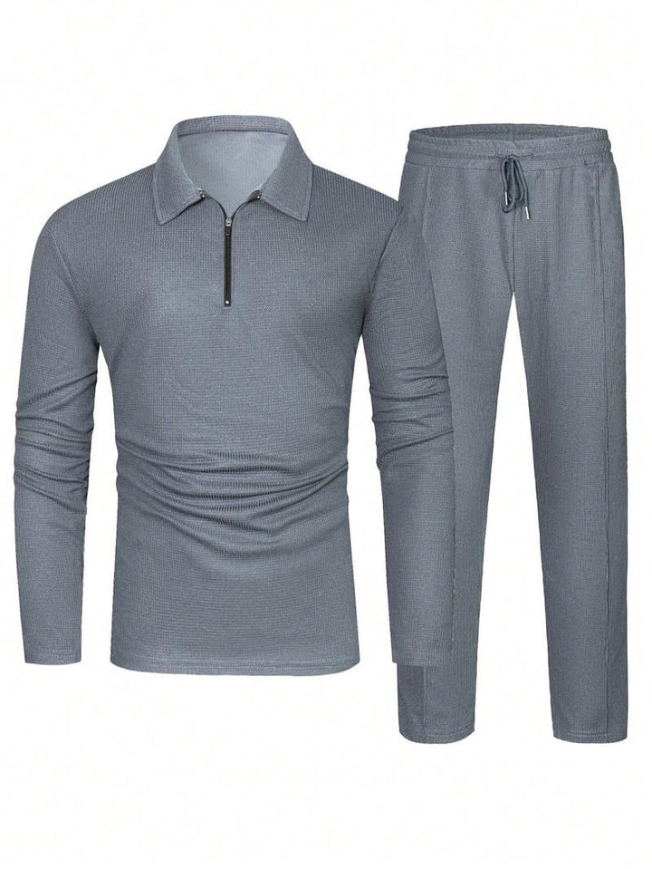 Man relaxing in a comfortable men's zip-neck lounge set. Stylish two-piece cotton blend for home or casual wear.