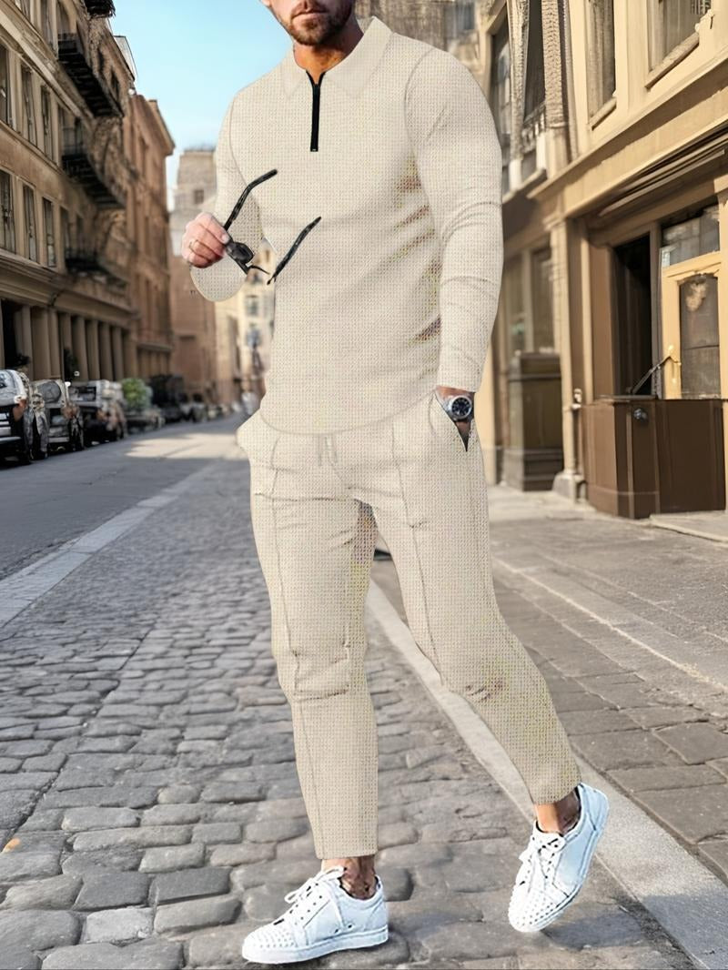 Model showcasing a men's comfortable zip-neck lounge set. Two-piece cotton blend for stylish, casual men's fashion.