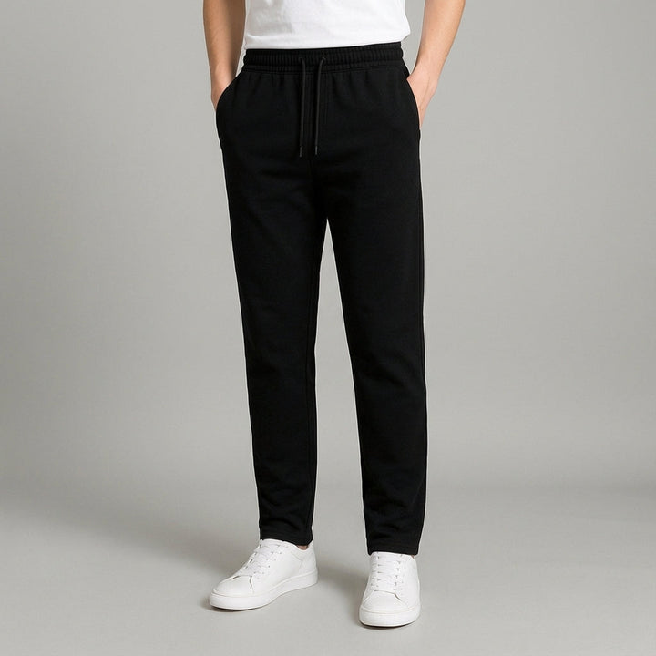 Model wearing men's tapered casual jogger pants with sneakers, demonstrating contemporary streetwear style.