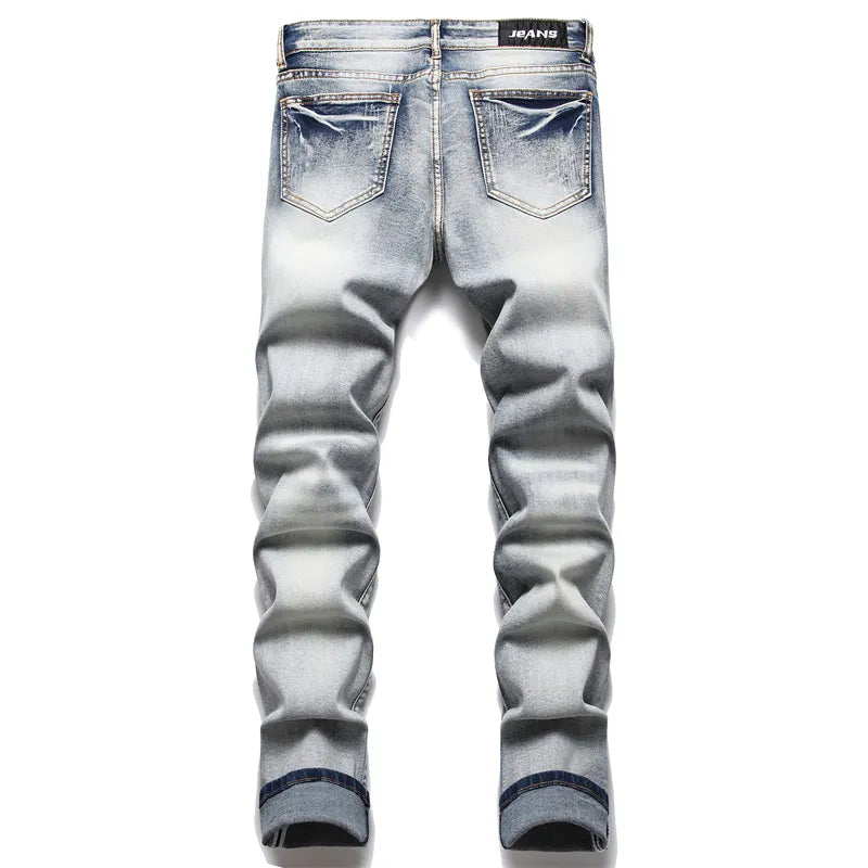 Fashionable men's distressed denim jeans, featuring prominent rips and a modern fit for an edgy look.