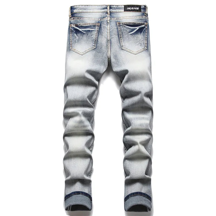 Fashionable men's distressed denim jeans, featuring prominent rips and a modern fit for an edgy look.