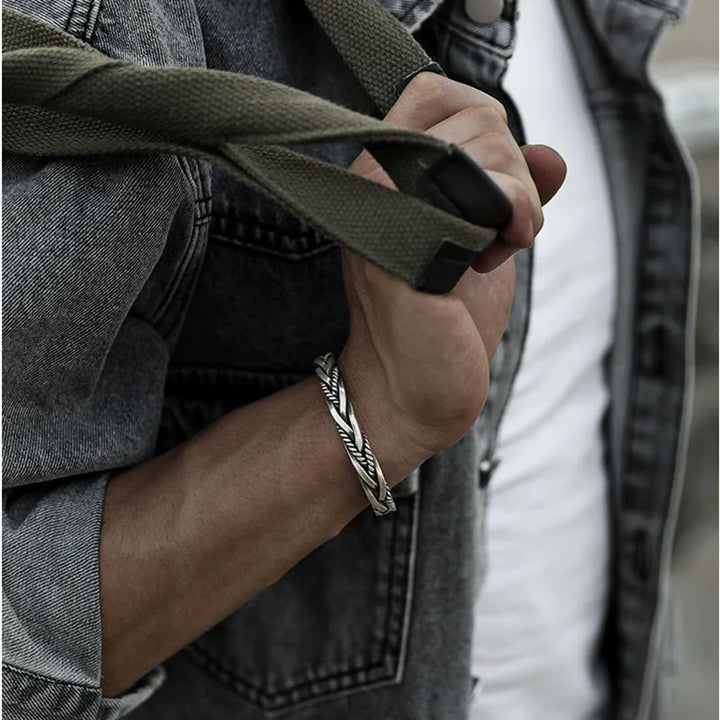 Hand modeling a men's bold sterling silver cuff bracelet with a distinctive twisted design. Adjustable for any wrist.