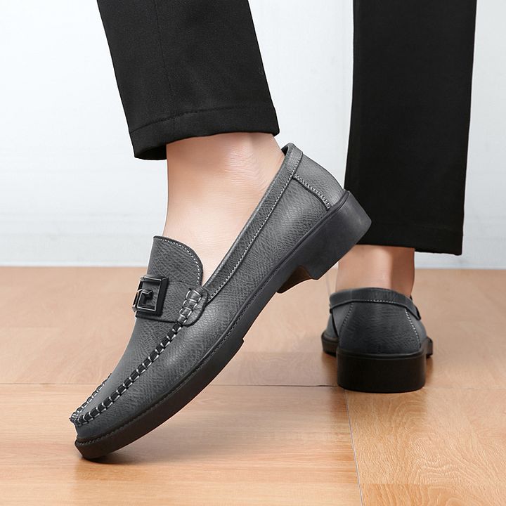 Men's black slip-on loafers, featuring a decorative buckle, perfect for a smart casual look.