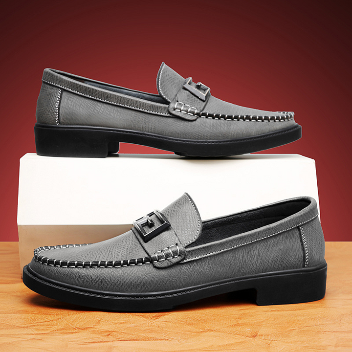 Elegant men's footwear: slip-on loafers with a distinctive buckle, offering both style and comfort.