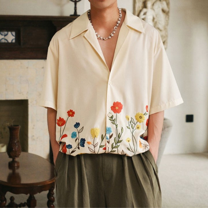 Bold men's vibrant floral print shirt. Stylish short-sleeve button-up, ideal for summer fashion.