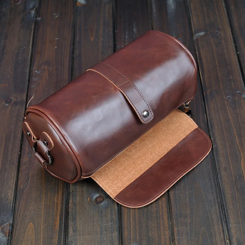 Close-up of men's vintage PU leather barrel shoulder bag, showcasing texture and classic style.