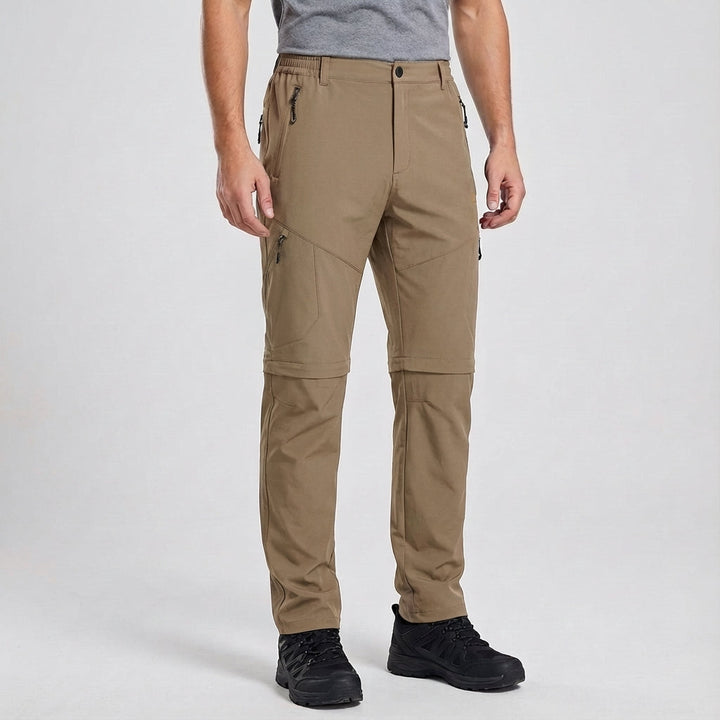 Detail of the zipper and pockets on men's convertible waterproof hiking trousers, practical for trekking.