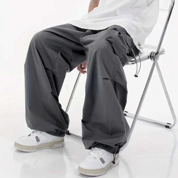 Man in versatile wide-leg cargo pants, walking in urban setting. Great for streetwear, outdoor, & comfort.