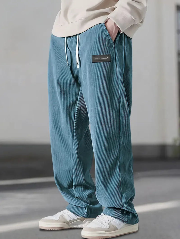 Soft corduroy men's wide leg pants, textured fabric, relaxed fit, adjustable waist for ultimate comfort.