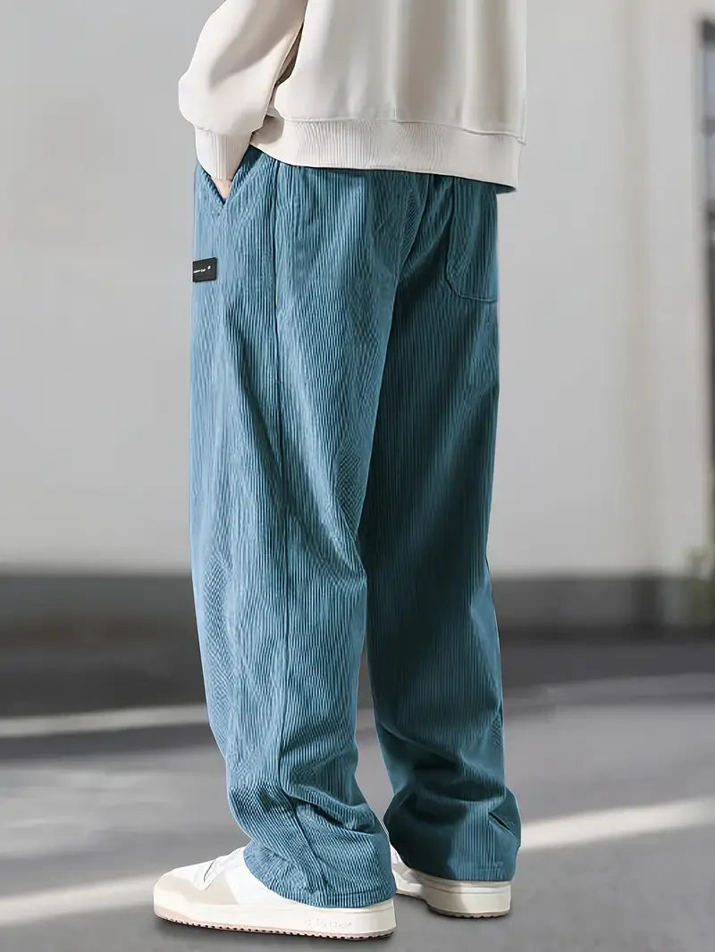Men's wide leg corduroy pants creating a vintage streetwear look, comfortable relaxed fit, soft texture.