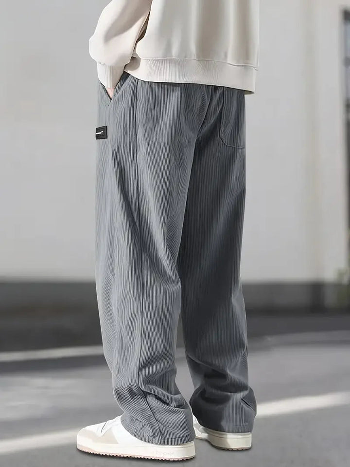 Front view: Men's wide leg corduroy pants, elastic waist, relaxed fit, showing comfortable streetwear style.
