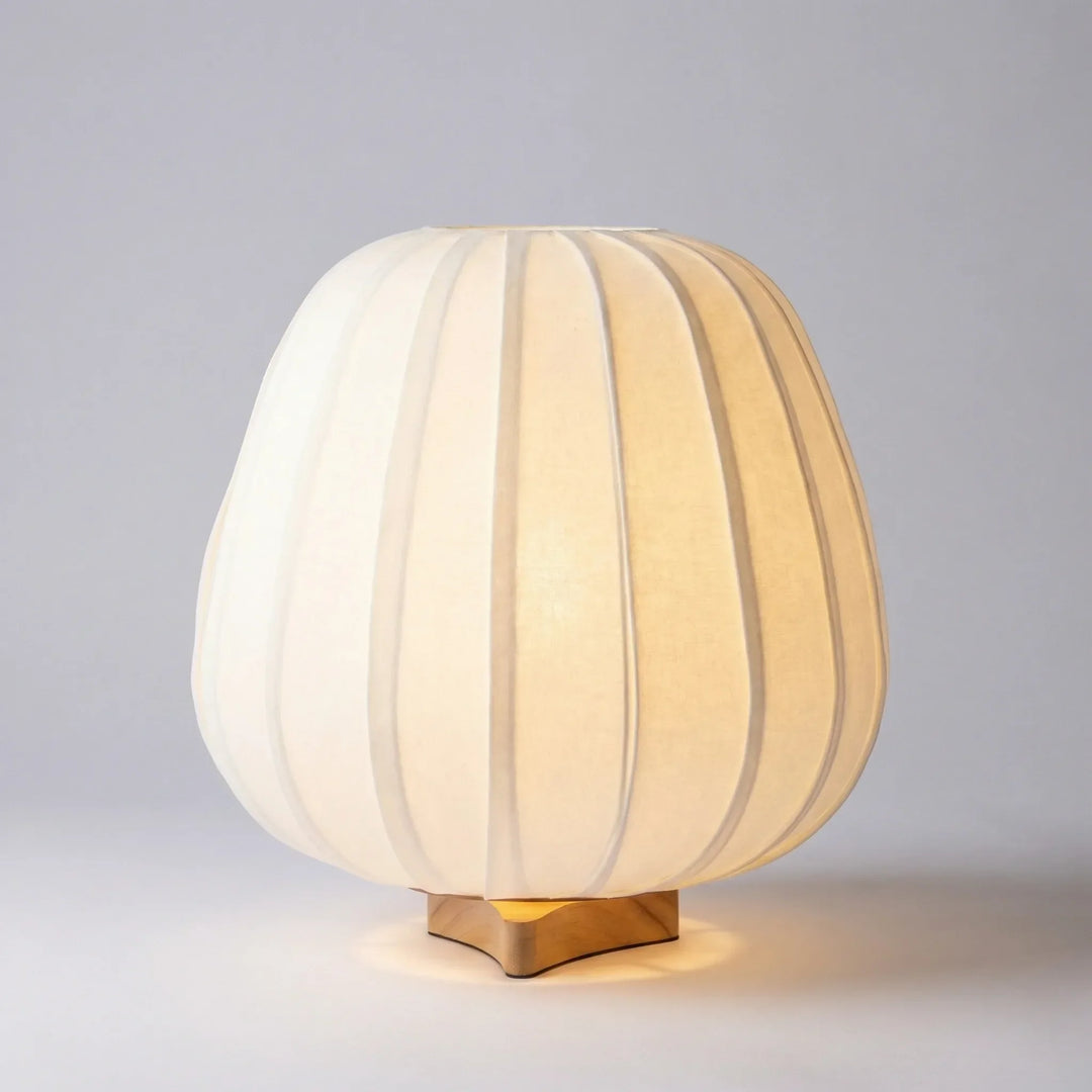 Bedroom scene featuring an AmbiNook minimalist table lamp providing cozy ambient light on a nightstand