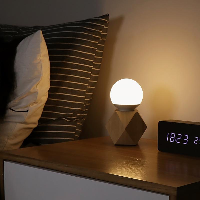 Elegant minimalist bedside lamp with a distinctive geometric base, ideal for contemporary home decor.