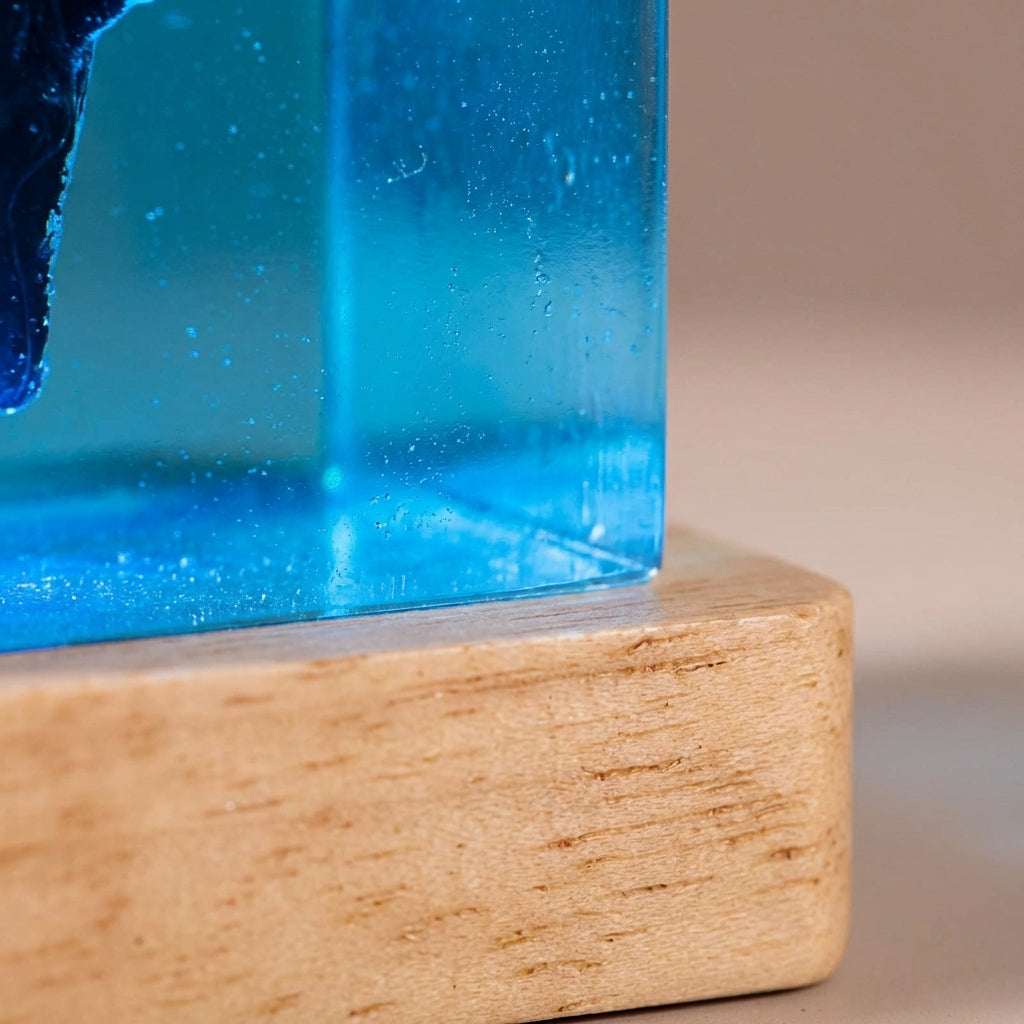 Close-up of unique landscape inspired table lamp, glowing resin art, warm LED light, natural wood base.