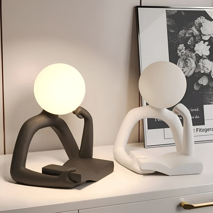 Resin LED desk lamp, sleek minimalist design, provides soft ambient lighting for any room.