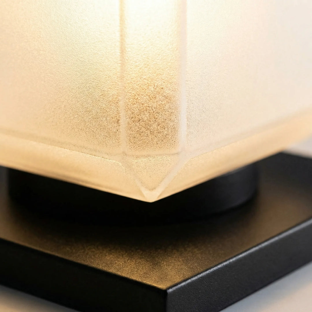 Modern cube solar lamp illuminating a garden path, minimalist outdoor lighting decor.
