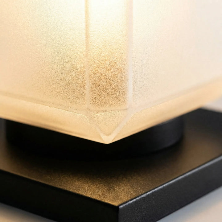Modern cube solar lamp illuminating a garden path, minimalist outdoor lighting decor.