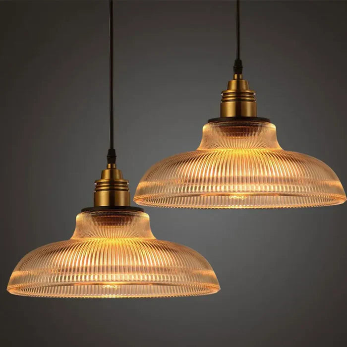 Modern clear glass pendant light with brass accents, ideal for dining room warm lighting.
