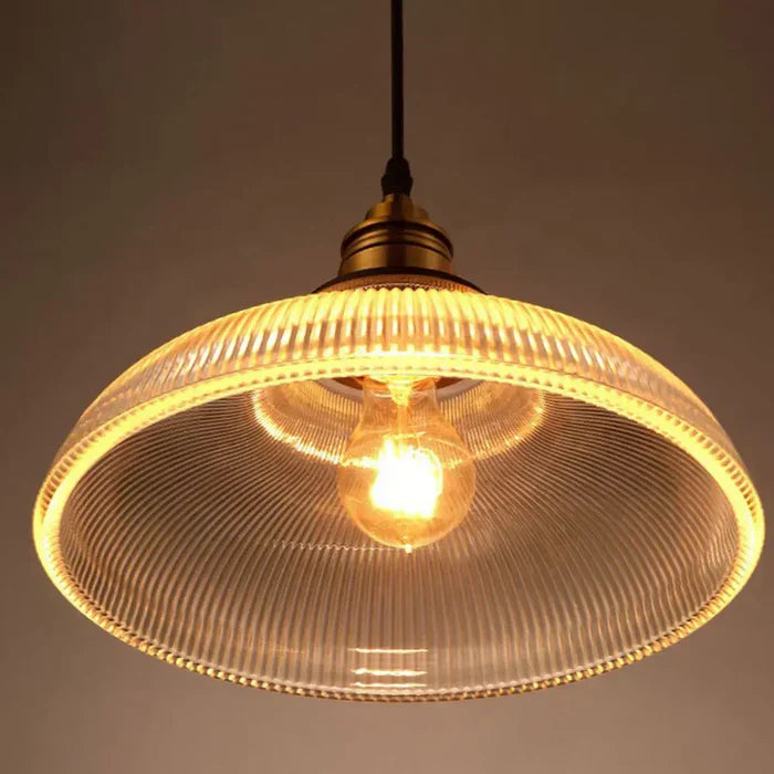 Elegant glass dome pendant light, casting warm illumination in a stylish dining area.