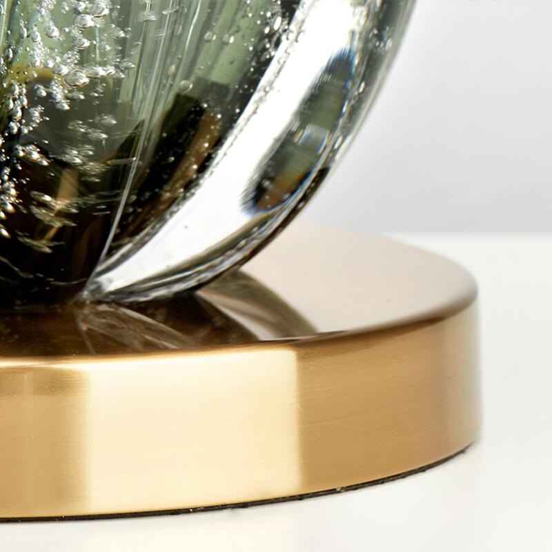 Modern green glass table lamp providing soft, ambient light, ideal as a decorative accent in any room.