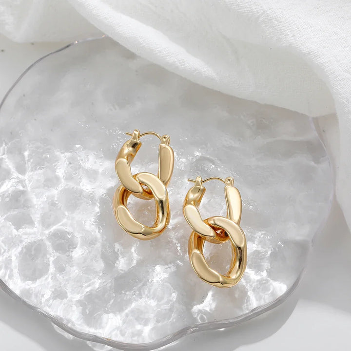 Pair of women's modern gold interlocking link earrings, chunky and stylish, perfect fashion jewelry.