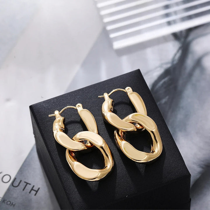 Contemporary women's gold interlocking link earrings, a bold chunky design elevating any modern outfit.
