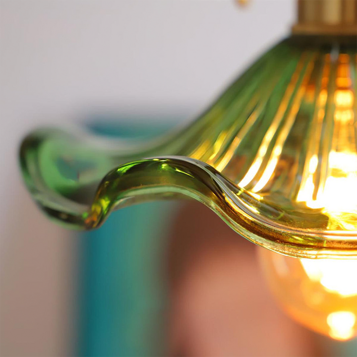 Unisex glass hibiscus pendant lamp with brass accents, a chic flower light for modern homes.