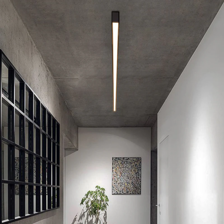 Energy-efficient linear LED ceiling light, industrial style, provides bright modern indoor lighting.