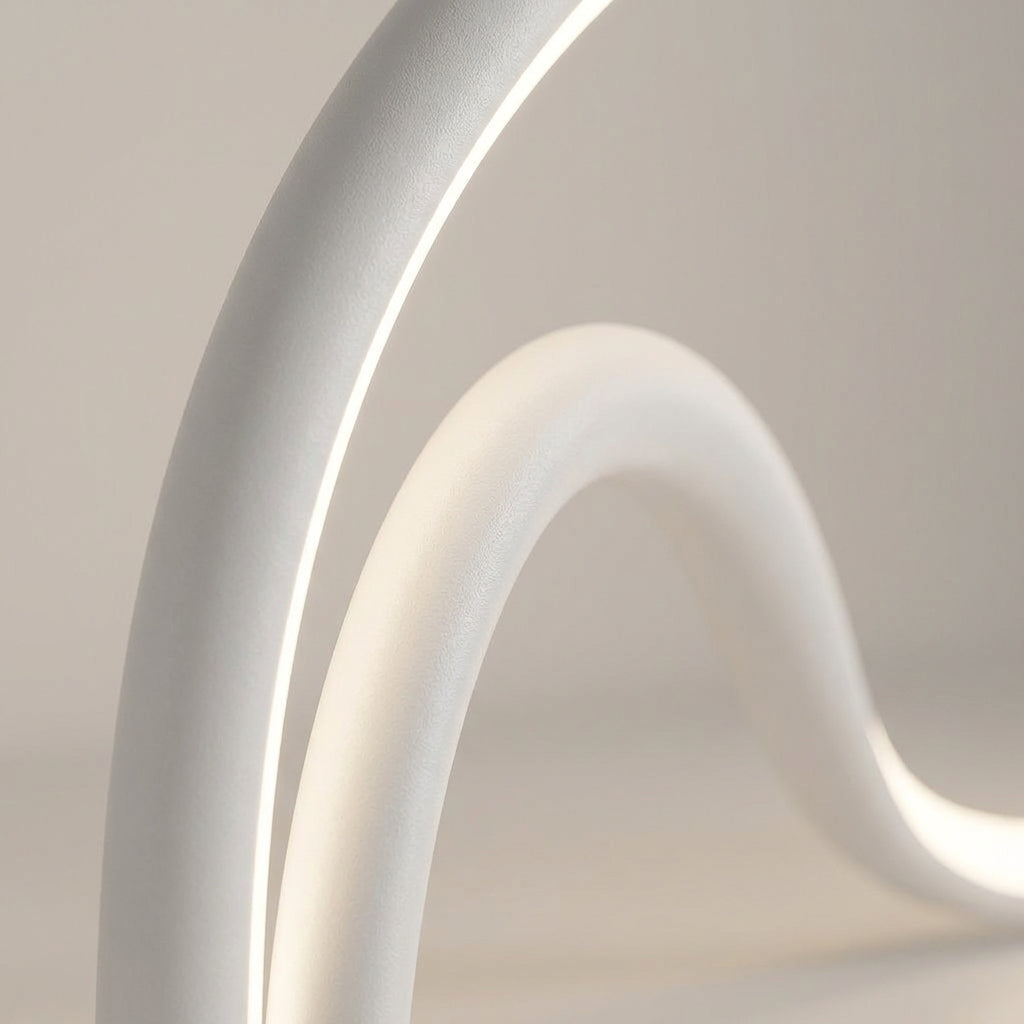 Close up of the Arcelle LED sculptural table lamp, showcasing its unique modern curved form and light.