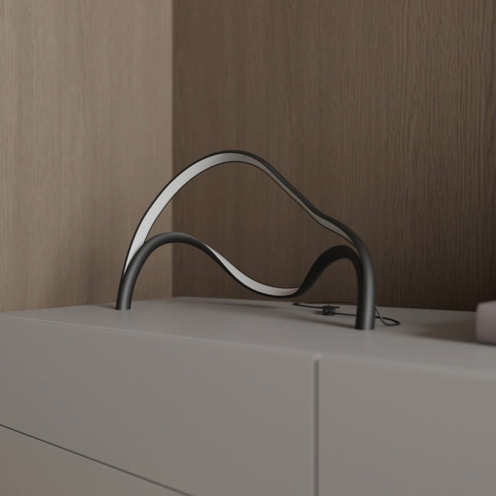 Stylish Arcelle modern LED table lamp, a sculptural lighting piece enhancing home decor on a side table.