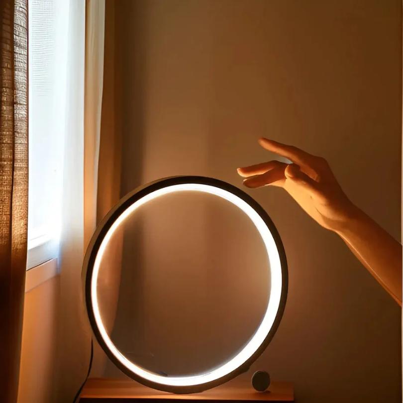 Modern LumaCircle Dimmable LED Night Light. Stylish table lamp provides ambient lighting for bedroom or office decor.