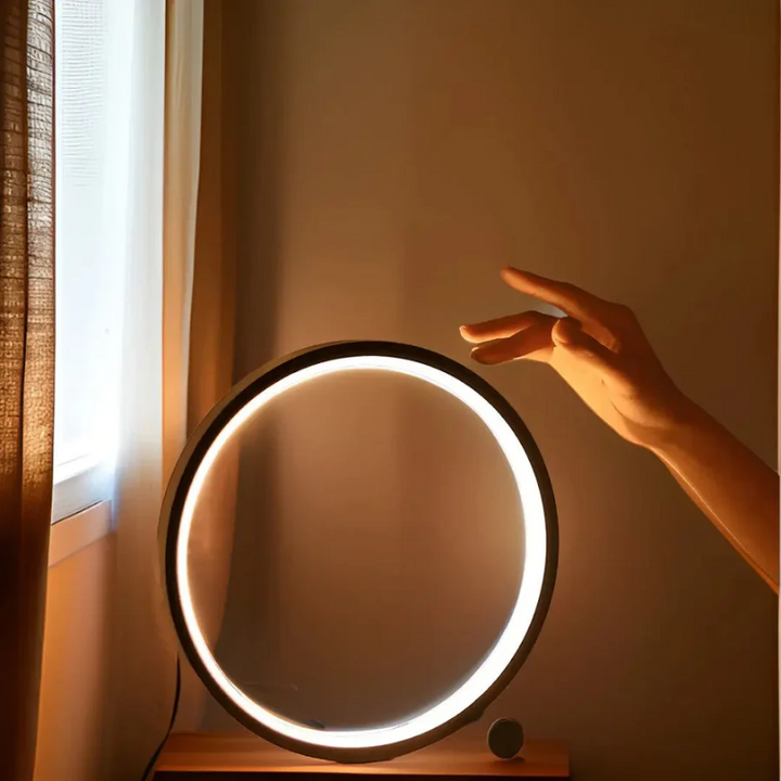 Modern LumaCircle Dimmable LED Night Light. Stylish table lamp provides ambient lighting for bedroom or office decor.