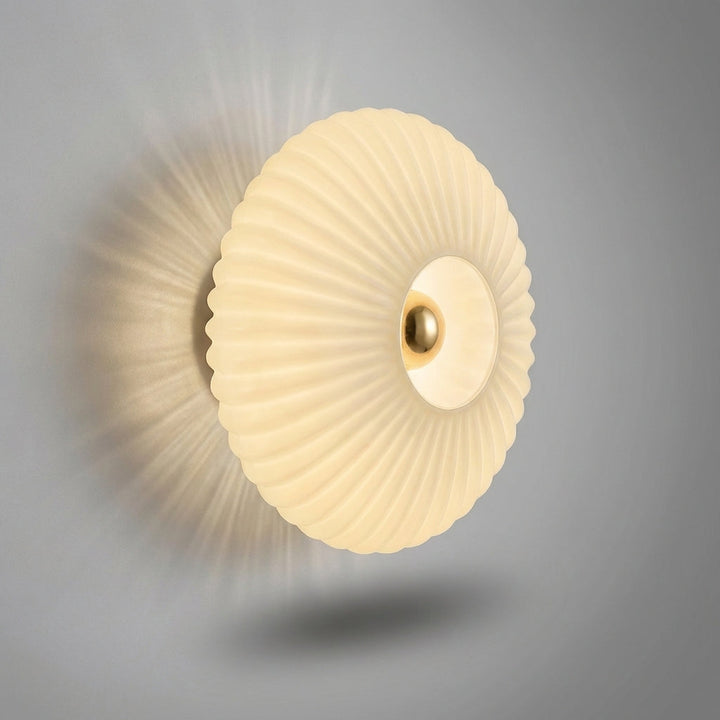 Sleek modern wall sconce, clear glass shade offering soft, ambient light.