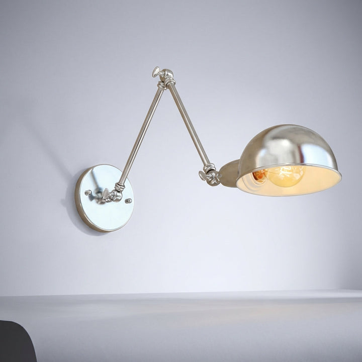 Adjustable wall-mounted lamp in polished silver, enhances any modern bedroom or living room
