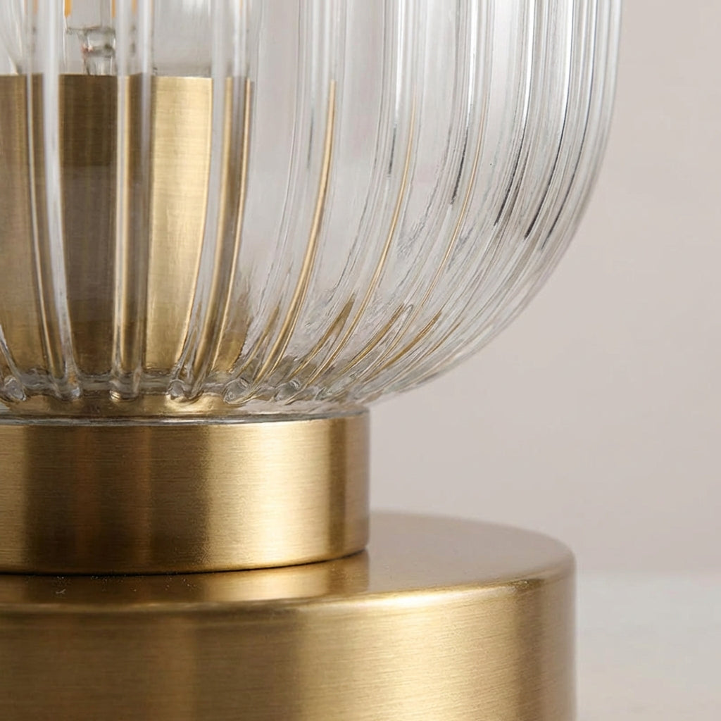 Elegant ribbed glass table lamp with a sleek metal base, ideal for bedroom or living room ambient lighting.
